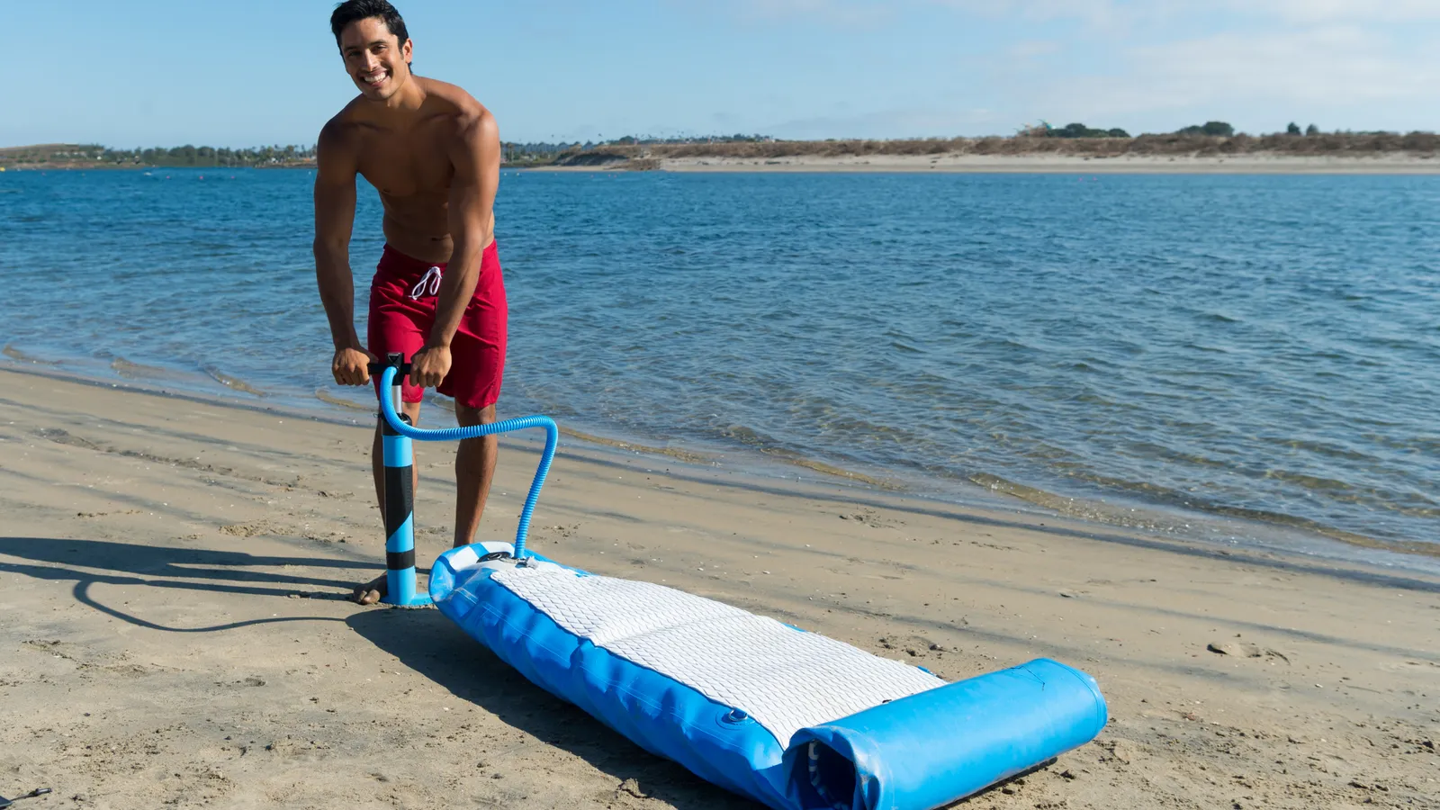 Inflatable paddle board being pumped up before a paddle