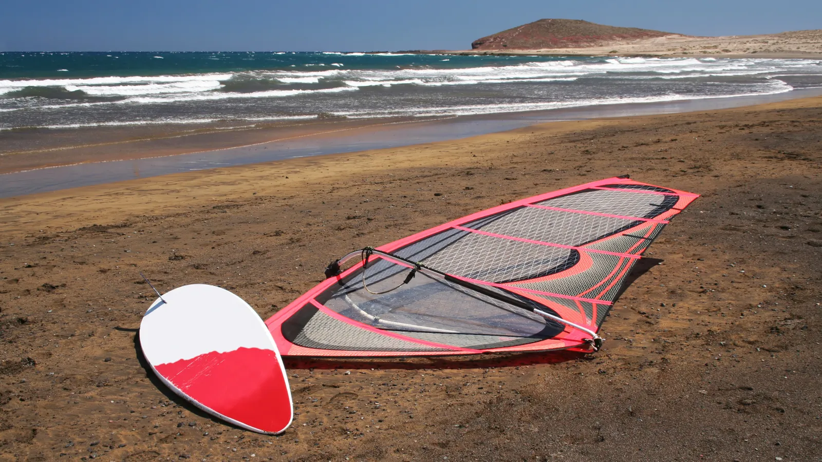 Windsurf sail being removed from the board