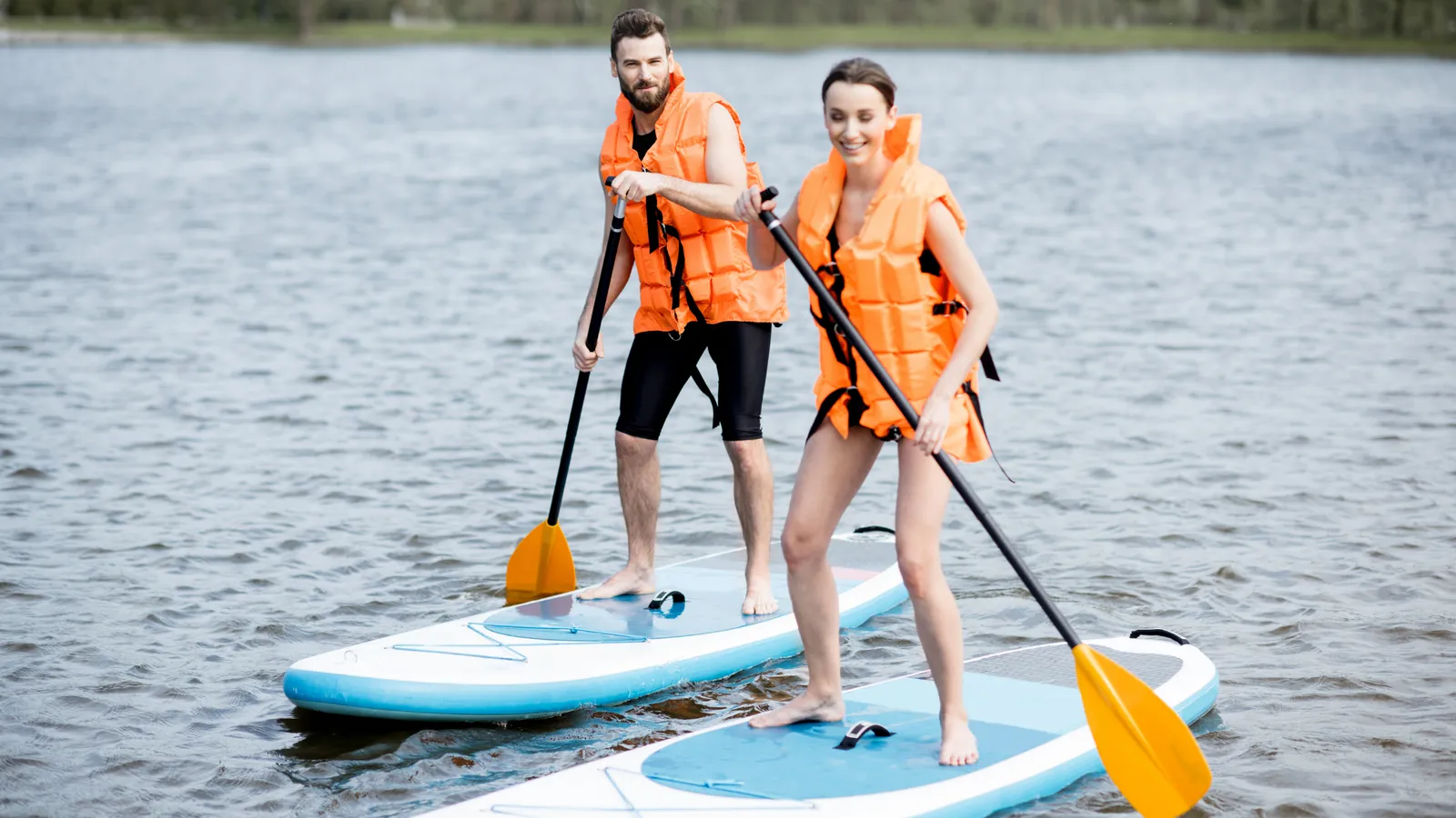 Paddle boarder wearing a life jacket on the water