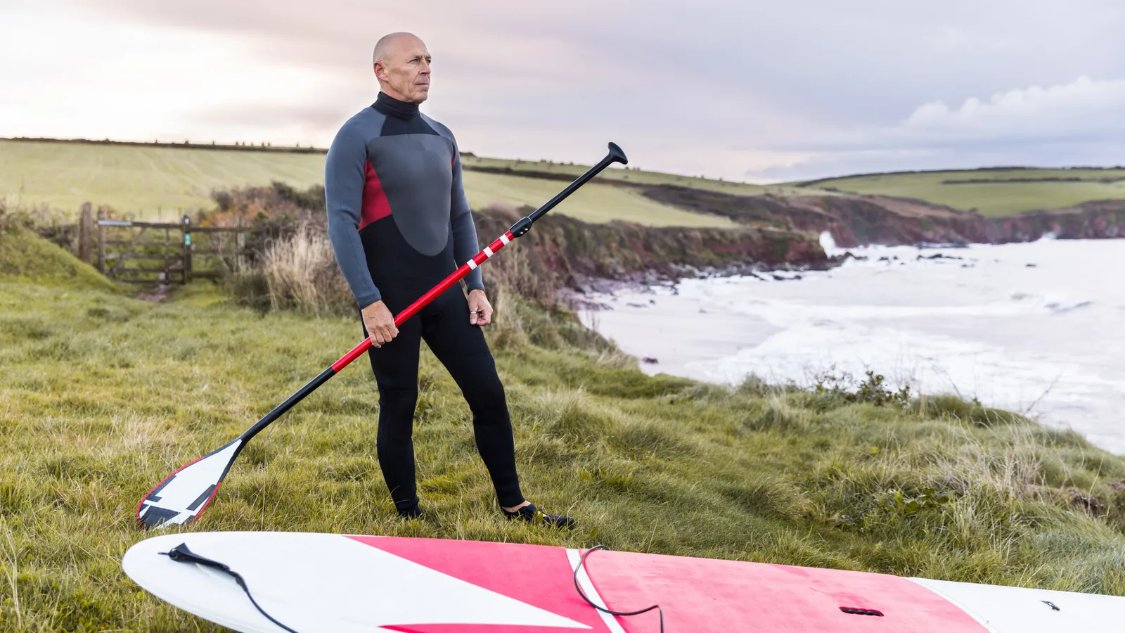 Paddleboarder wearing a wetsuit on cool water